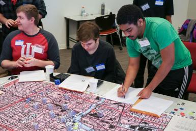 Students gather around a map