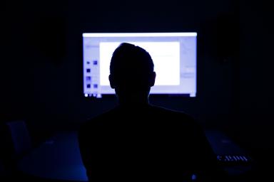 A person working at a computer in the dark