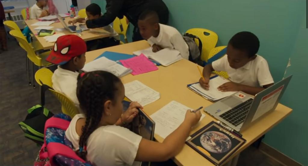 Children working on aschoolwork together at a table.