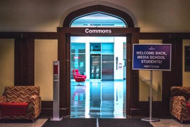 A "Welcome Back Media School Students" sign and a hand sanitizer dispenser sit outside the entrance to the Franklin Hall commons