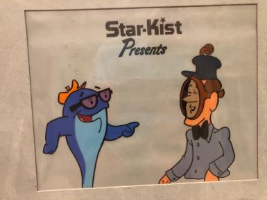 A cartoon of Charlie the Tuna and a man wearing a mask. It says "Star-Kist presents."