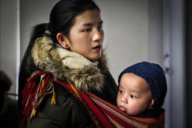 Mother holding child in woven sling