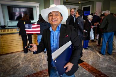 A man holds an American flag after his naturalization ceremony.