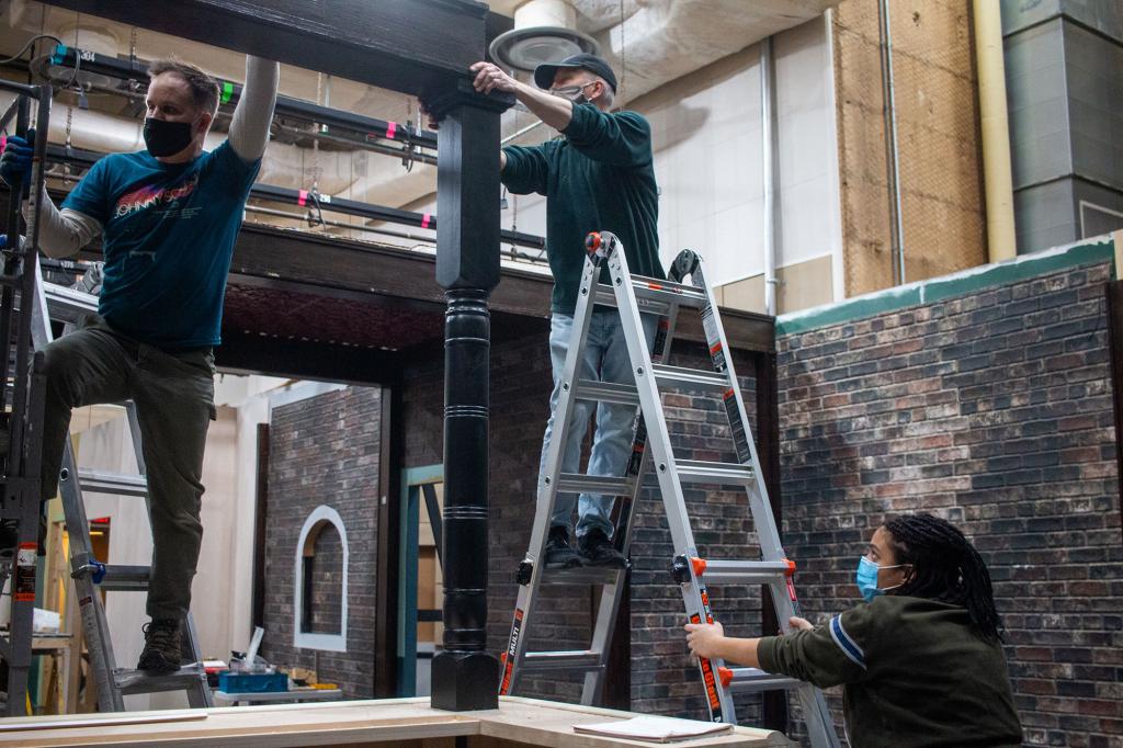 Media School students assist senior lecturers Craig Erpelding and Steve Krahnke in raising a large beam to support the ceiling in IU's new soundstage. 