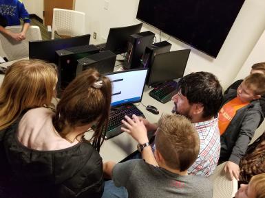 Andrew Behringer shows Stalker Elementary School students a computer in the game design lab