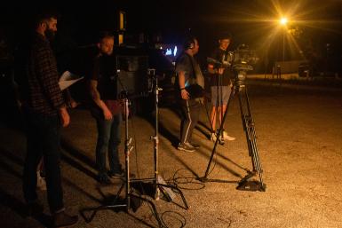 Four students using cameras on tripods