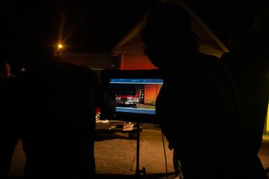 Students look at a screen that shows a red Chevy.