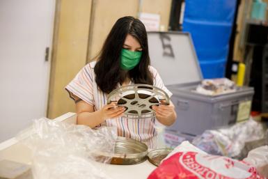 Amber Bertin inspects a reel of film