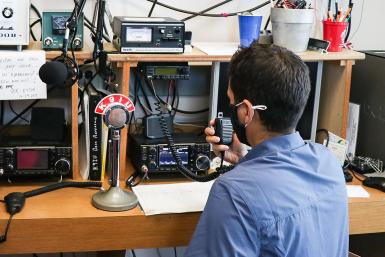 Jayson Deese speaks into an amateur radio receiver.