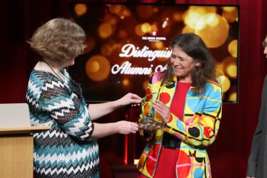 Millicent Martin presents the Distinguished Alumni Award trophy to Stephanie Becker.