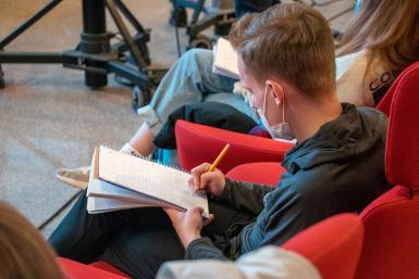 A student taking notes in the Franklin Hall commons