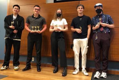 Five students posing with trophies