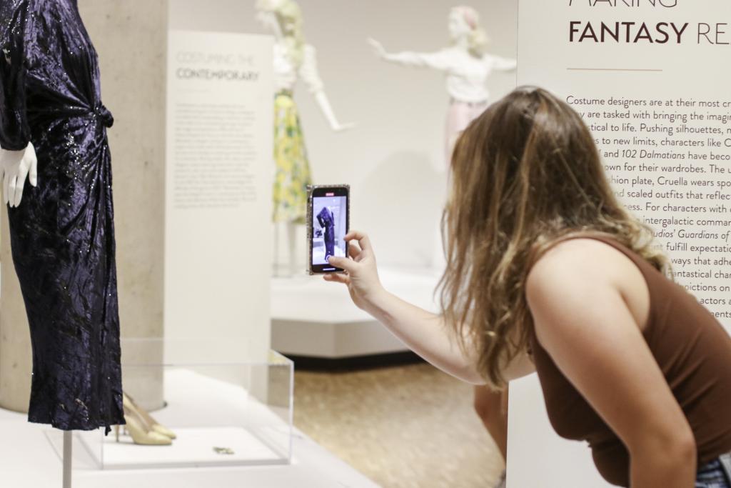 A student photographs a dress.