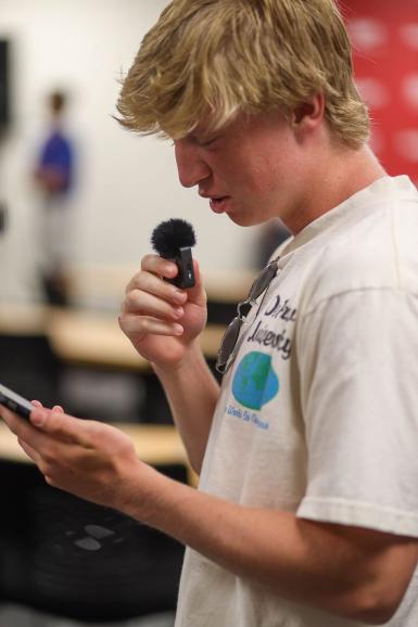 A student speaking into a microphone