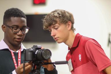 Two students look at a camera