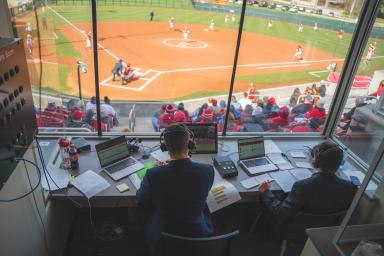 Students in a softball broadcasting booth