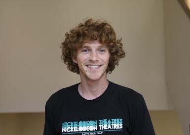 Headshot of Cole Nelson in front of beige wall