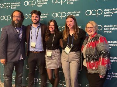 Five people stand in front of a green Associated Collegiate Press backdrop