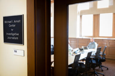 The entrance to the Arnolt Center with a plaque reading "Michael I. Arnolt Center for Investigative Journalism" displayed on the wall outside the Center.