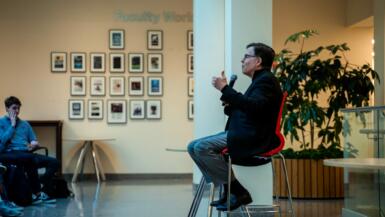 Sportscaster Bob Costas sits in the Franklin Hall commons speaking to students.