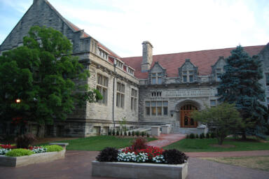 A wide shot of Franklin Hall with blooming flowers and trees.