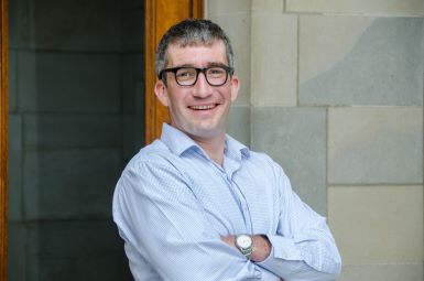 Headshot of Julien Mailland standing outside with arms casually crossed.