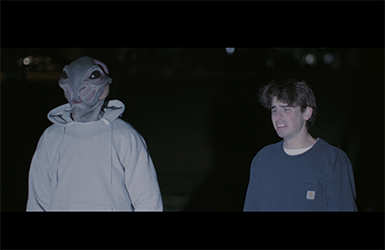 Screen capture from "The Black Sphere" showing an alien and dismayed human standing beside each other.