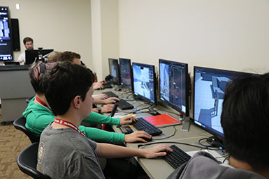 Students sit at computers. 