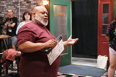 Bear Brown holds a slate board while talking to students.