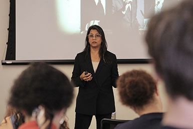 Sonia Shah stands in front of students while speaking. 