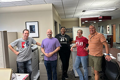 Five people stand in the BFCA office for a photo. 