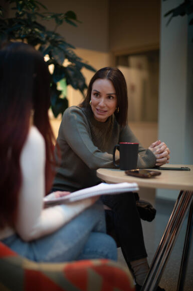 An image of Catt Sadler speaking to an interviewer. 