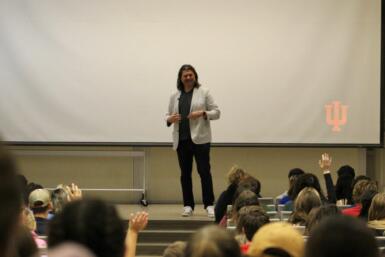 Galen Clavio stands at the front of a class lecturing to students.