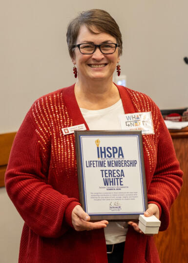 HSJI Director Teresa White holds the plaque for her IHSPA Lifetime Membership award.