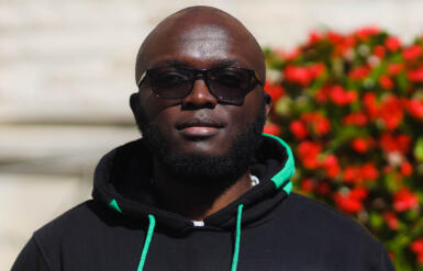 A headshot of Kevin Mudavadie with greenery behind him.