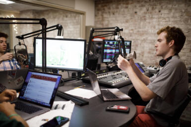 WIUX staff members sit in a studio.