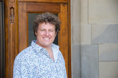 Headshot of Bryant Paul standing in front of a door.