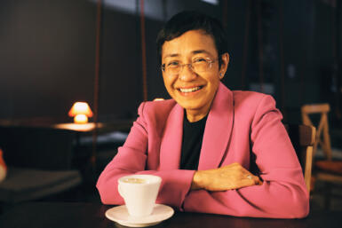 Maria Ressa sits at a table with a teacup.