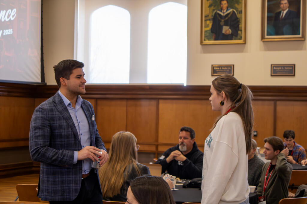 Griffin Gonzalez stands and speaks to a student.