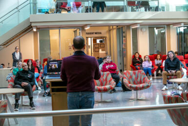 Ken Mack stands in front of students sitting in chairs in Franklin Hall commons.