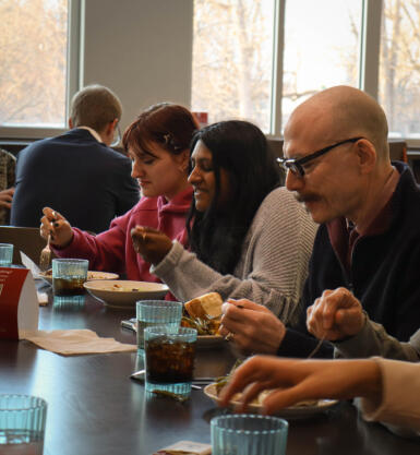 Students and David Tolchinsky eat dinner at a table.