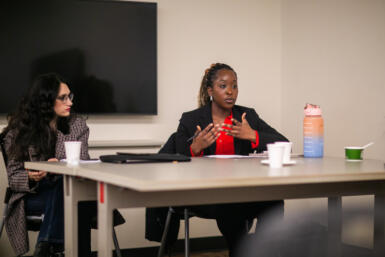 Two women sitting at a table speaking at Common Ground.