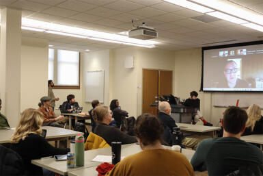 Cory Doctorow speaking over zoom to a room full of attendees at the Common Ground event.