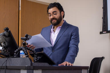 Photo of ramón resendiz redaing off of a peer while giving his keynote speech.