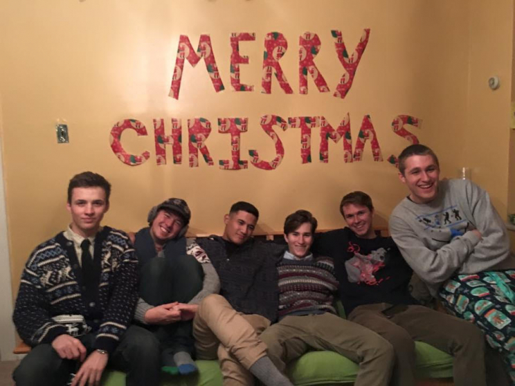 Six men sitting on a couch under the words "Merry Christmas"