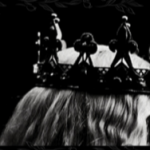 Black and white. Upper third of a woman's head wearing a crown