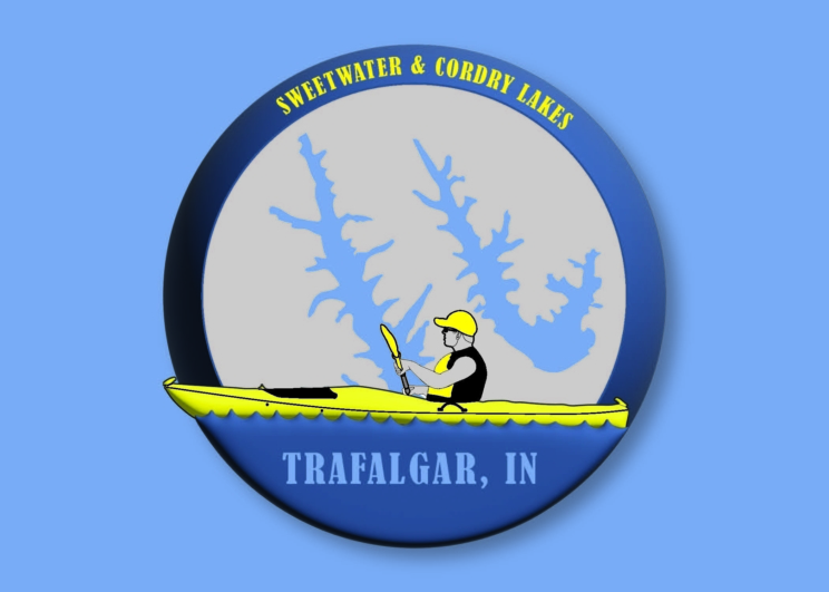 A sticker for Trafalgar, Indiana, featuring a person in a bright yellow kayak. There is text over the top of the sticker reading, "Sweetwater & Cordry Lakes."
