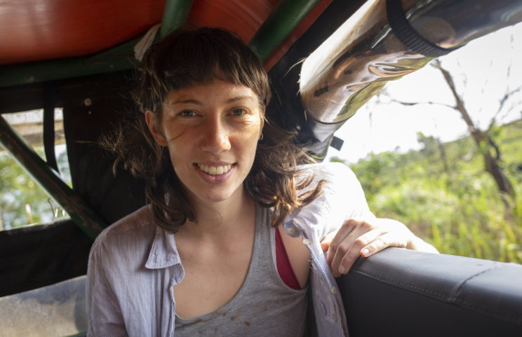 Hali Tauxe sits by the window inside a vehicle.