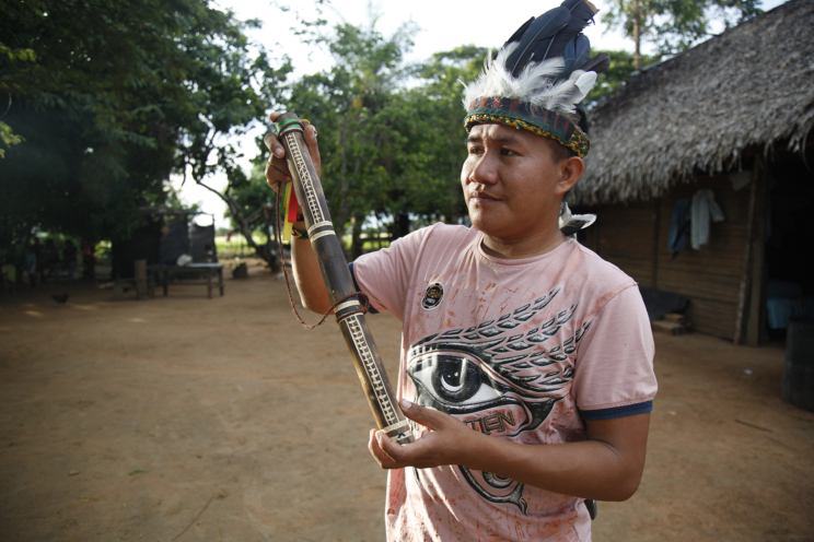 A man holds a wooden pipe. 
